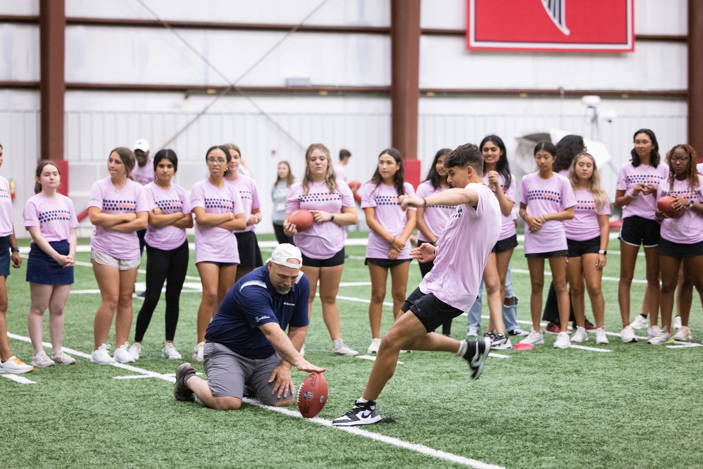 Group of First Tee participants playing football at the Atlanta Falcons field.
