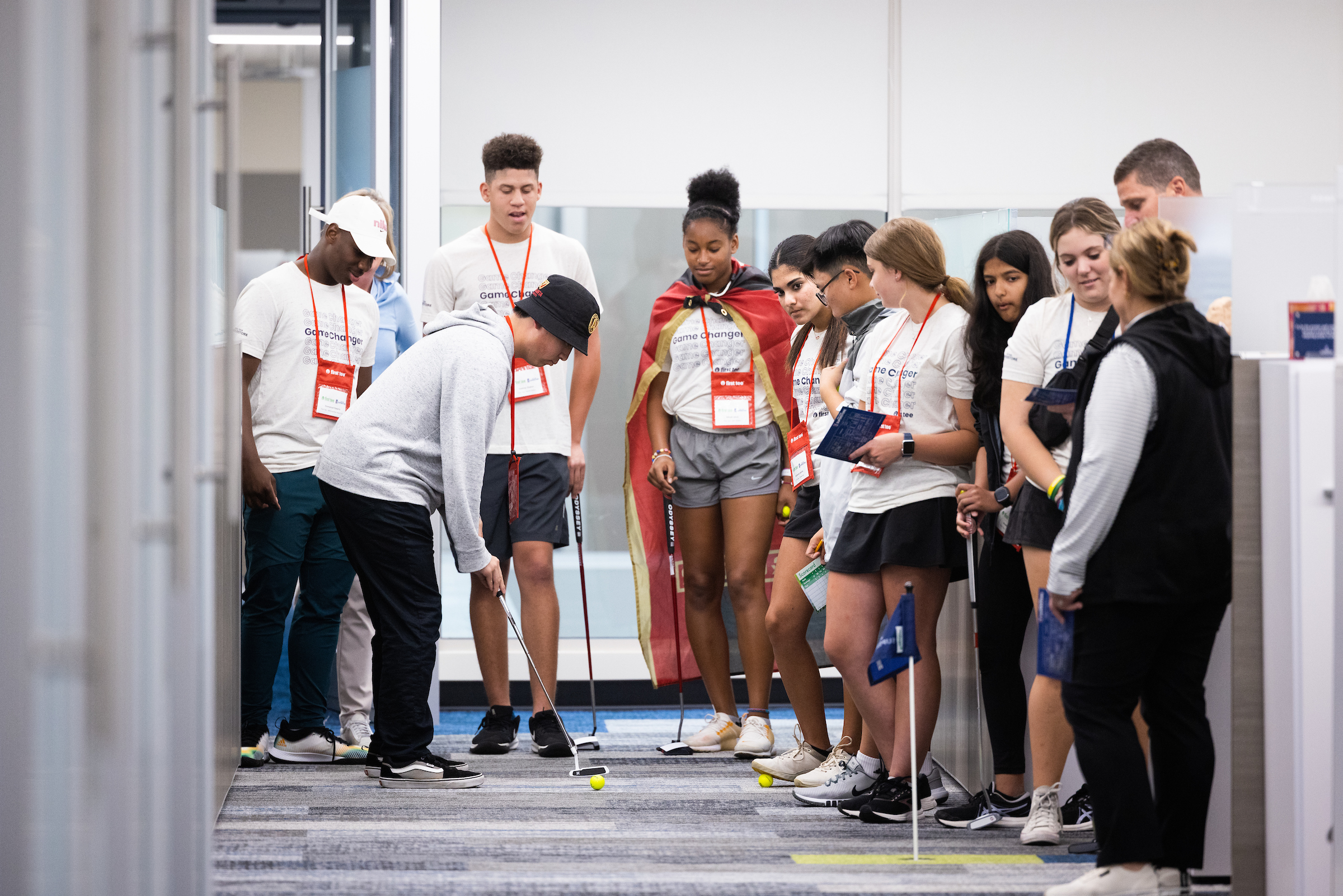 Group of First Tee participants putting in an office.