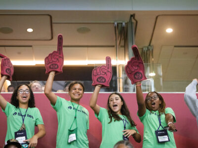 Four First Tee participants cheering at a soccer game