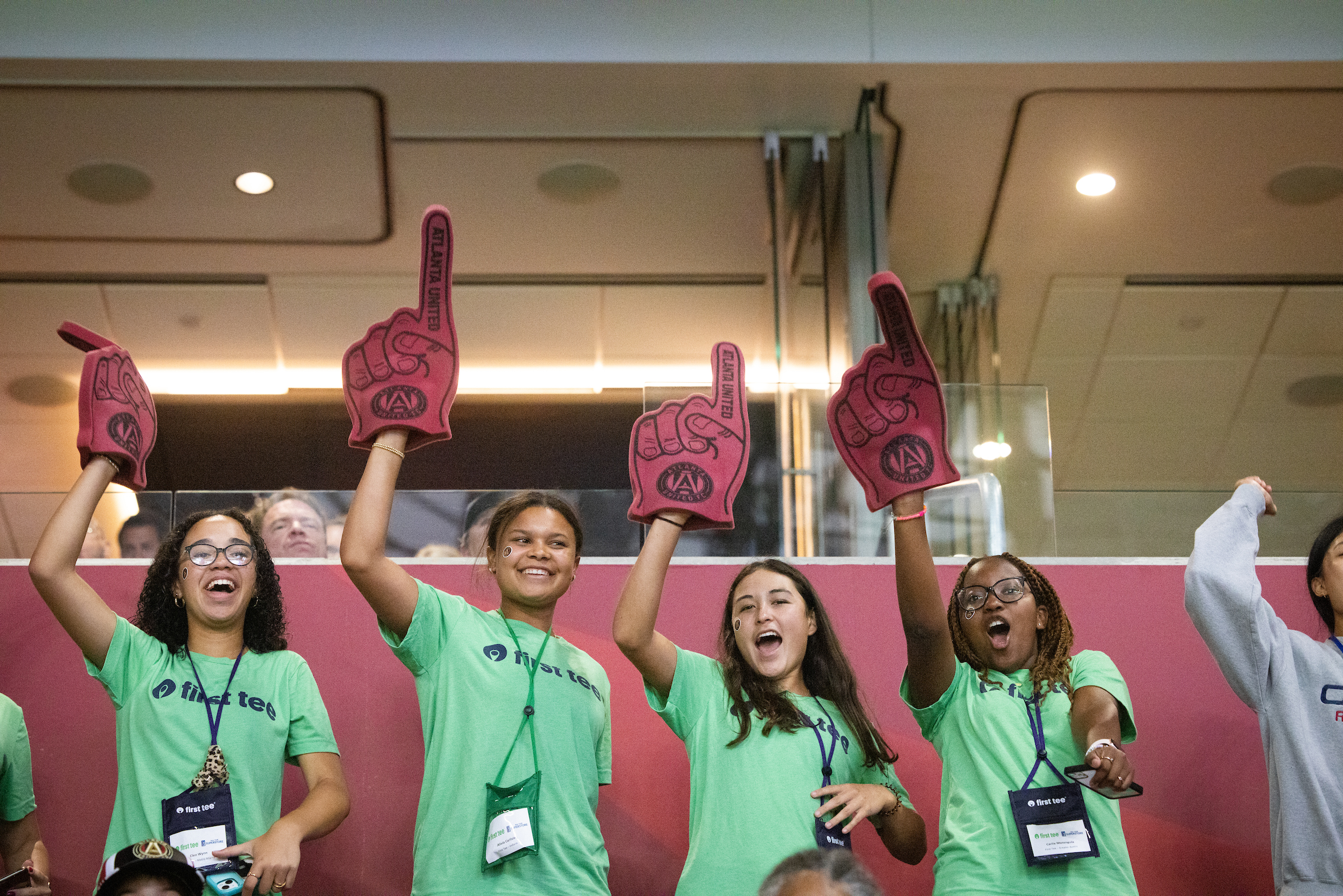 Four First Tee participants cheering at a soccer game