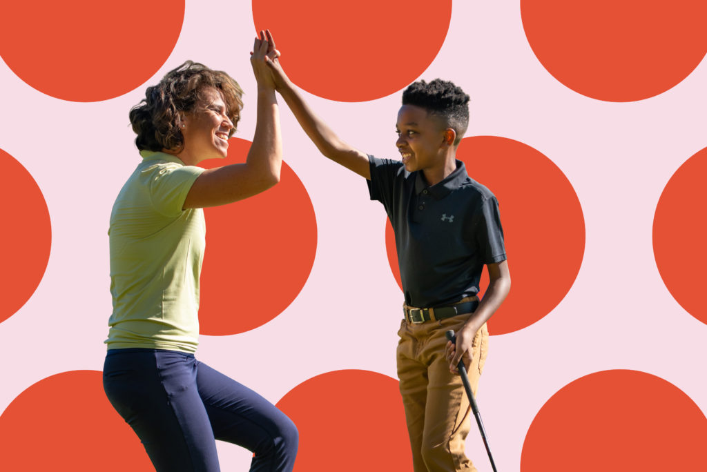 First Tee participant and coach high-fiving.