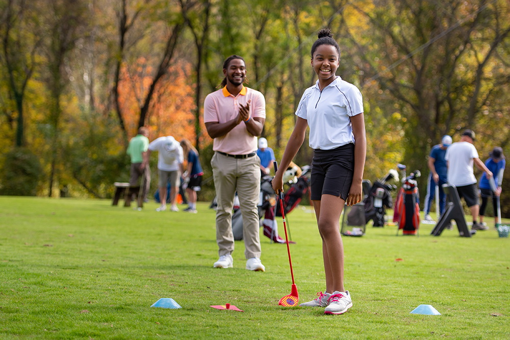 First Tee mentor cheers on participant.